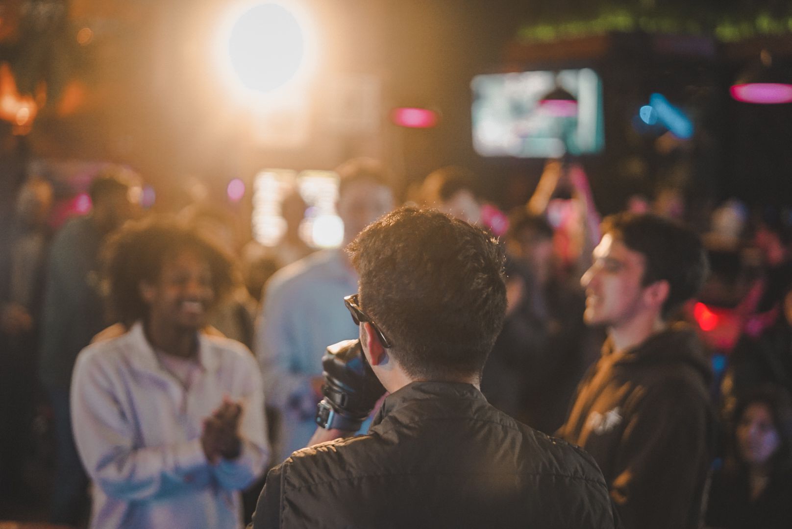 SUSH 28 seen from behind, singing to a smiling crowd